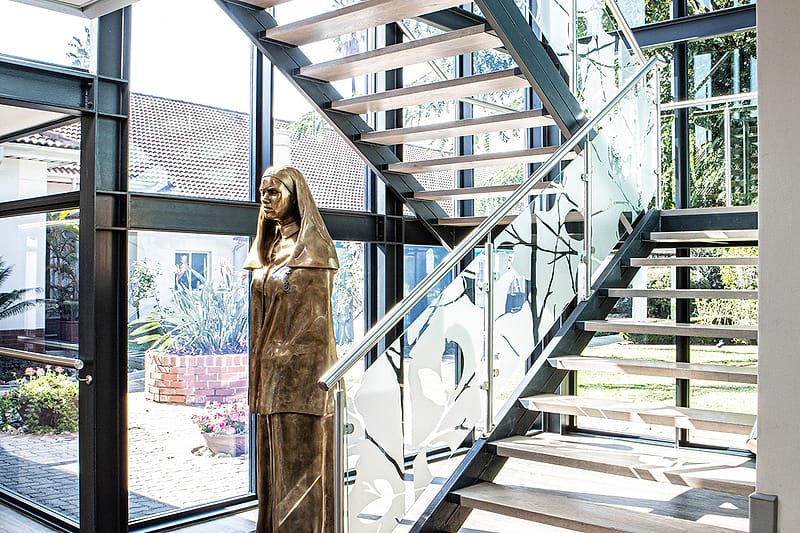 The glazed stairwell with the bronze figure of a nursing sister at its foot.